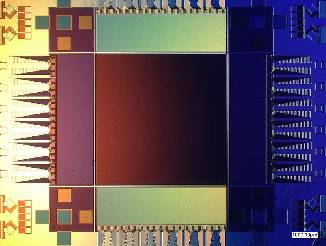Optical micrograph of the 400,000-pixel superconducting nanowire camera die, showing the central detector array surrounded by tapered readout fan-outs, with a 1 mm scale bar.